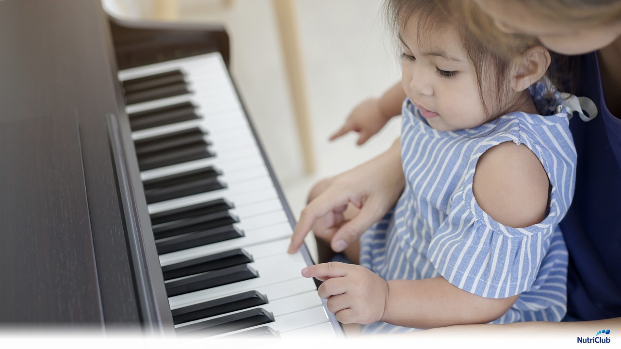 Baby girl learning to play piano