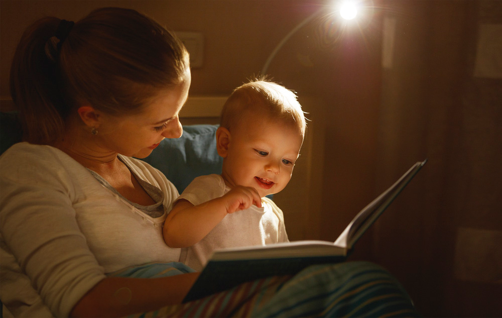Dem Baby beim Einschlafen helfen und eine Gute-Nacht-Geschichte vorlesen.