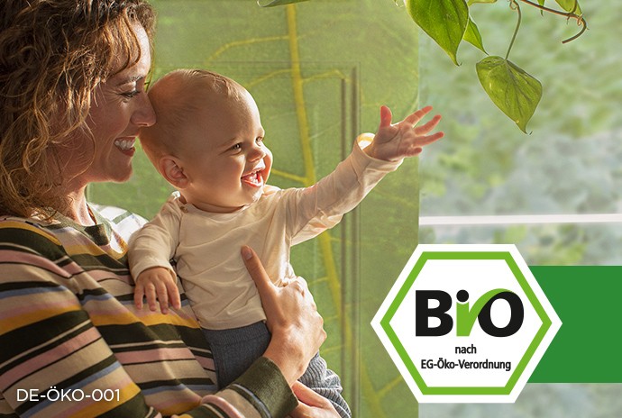 Bio Siegel Deutschland und Mama die glückliches Baby auf dem Arm hält