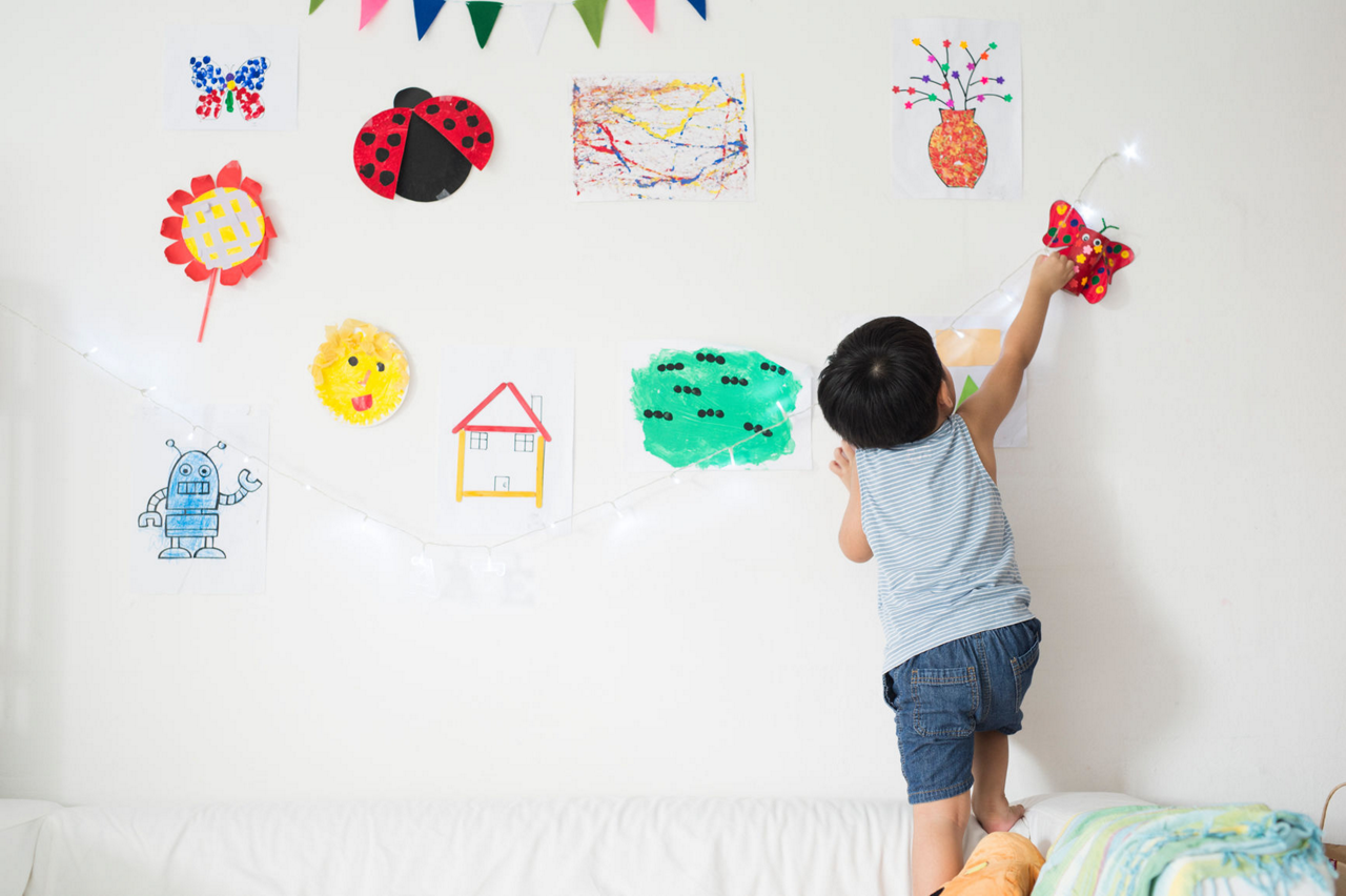 Boy playing with artwork on wall