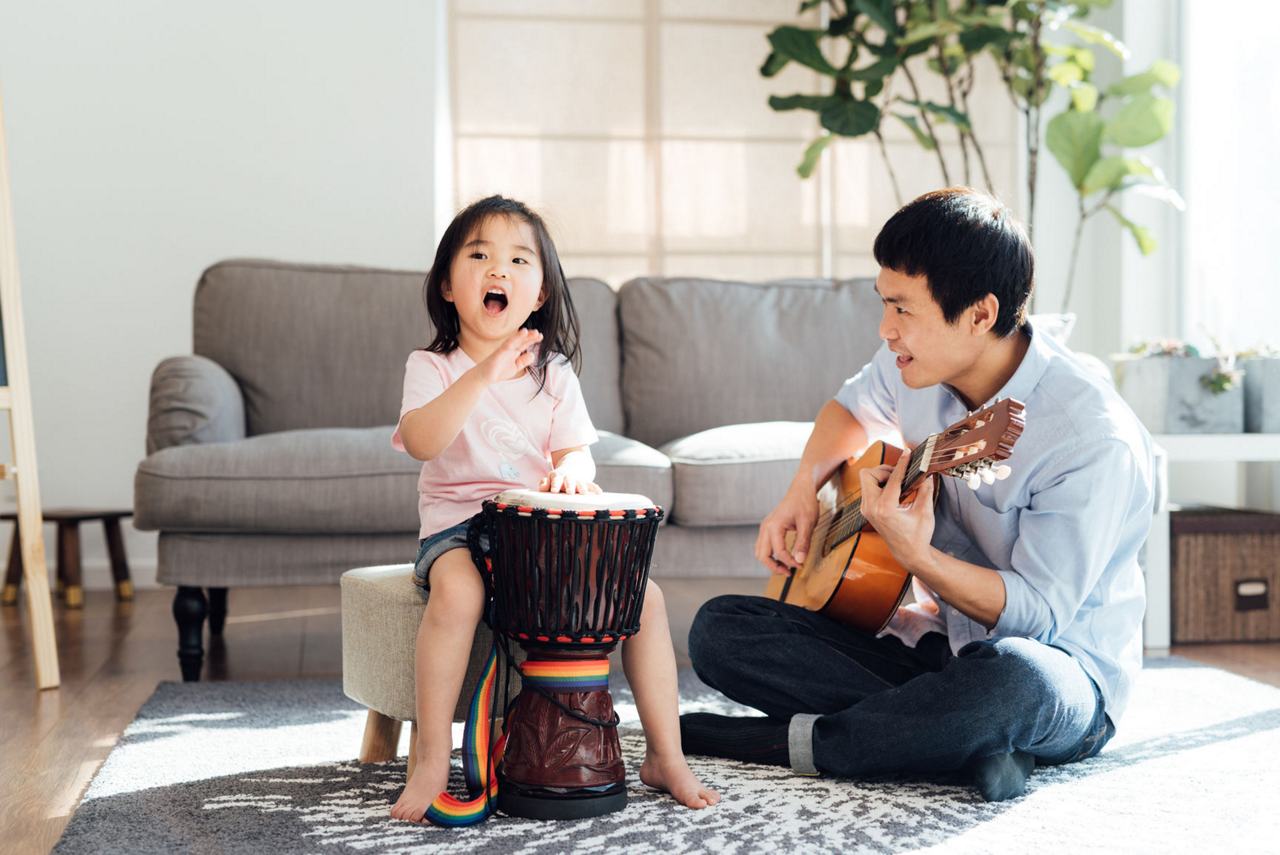 Girl playing drums with dad