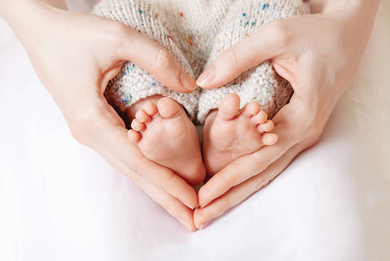 Baby-Füße werden als Herz zusammengehalten