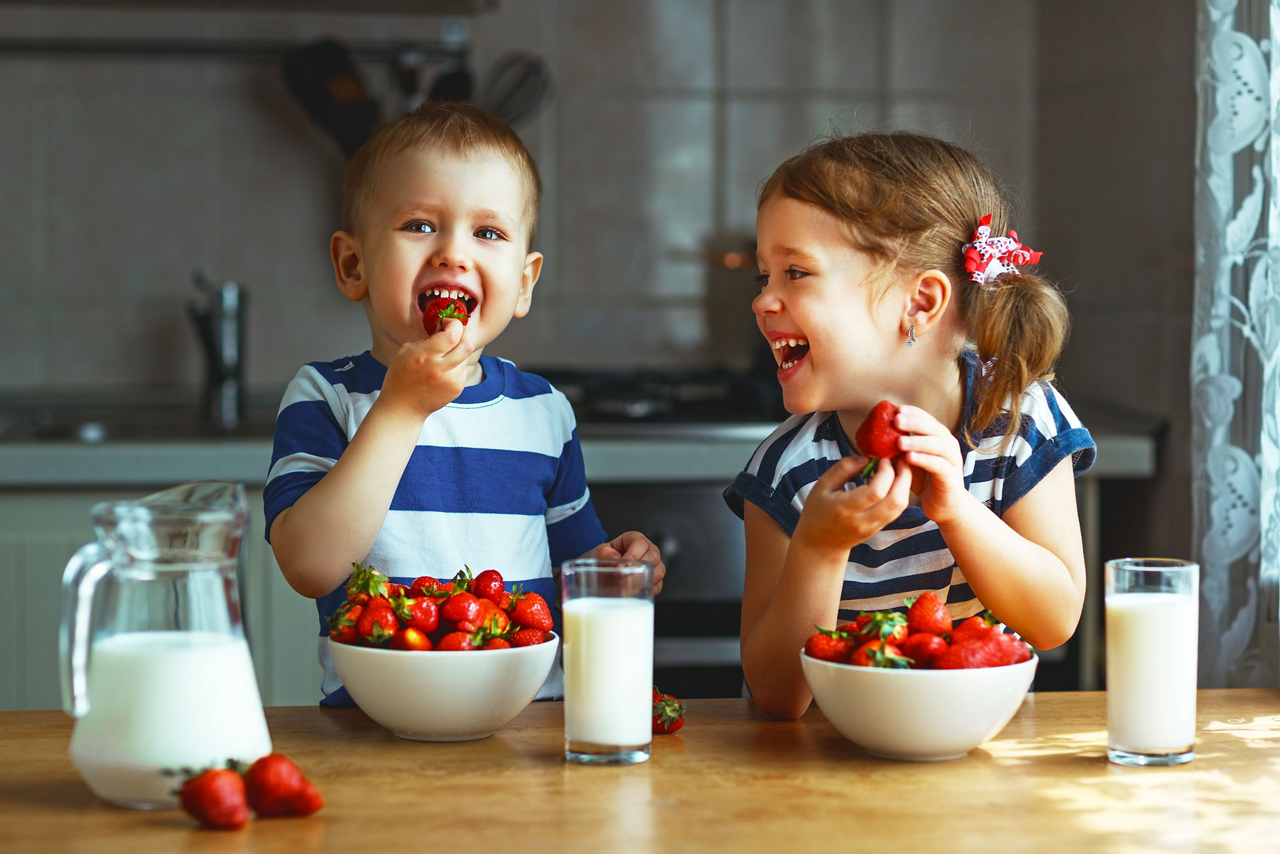 Glückliche Kinder essen Erdbeeren