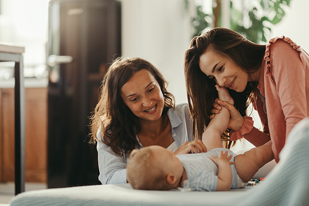 Zwei Frauen lächeln Baby an 