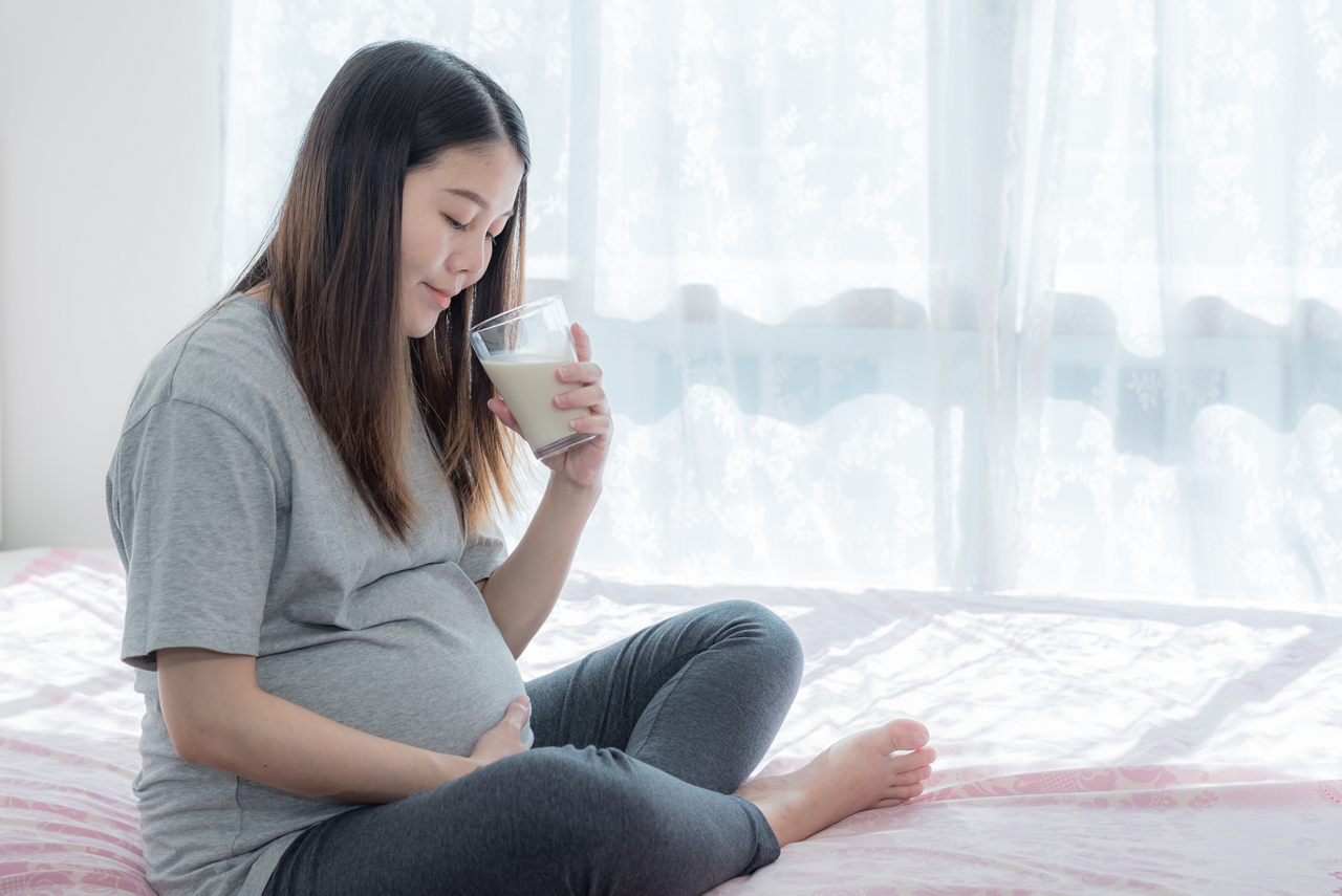 The 24th-week pregnant woman having healthy milk before bed