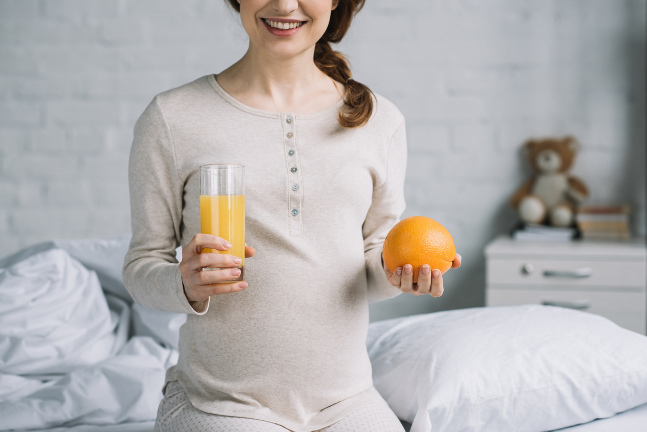 The 22nd-week pregnant woman having orange juice for vitamin C boosting