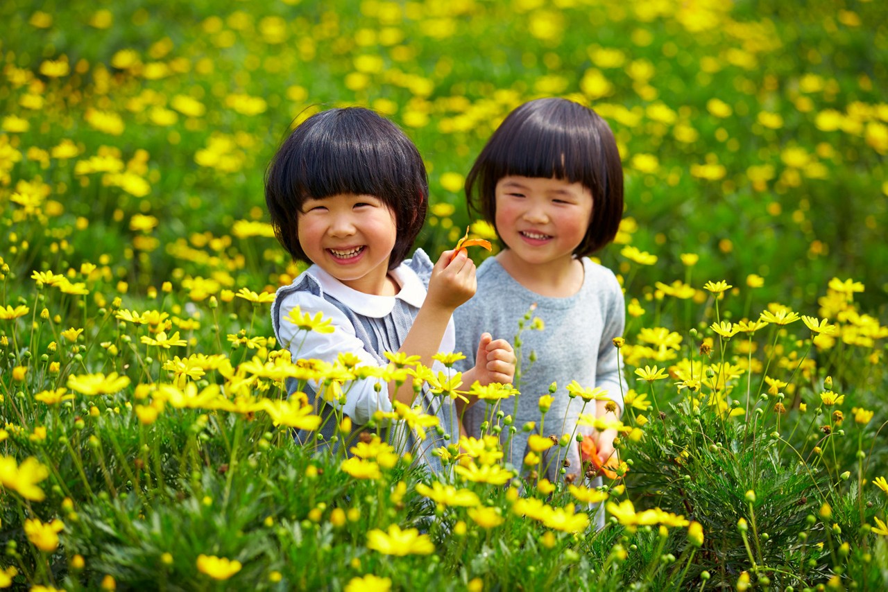Two happy little asian girls in the spring garden
