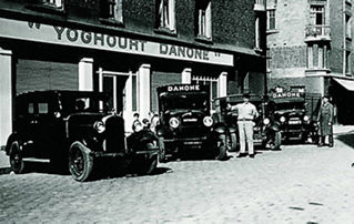 Old picture of Danone cars in front of the first Danone's factory in Paris - History