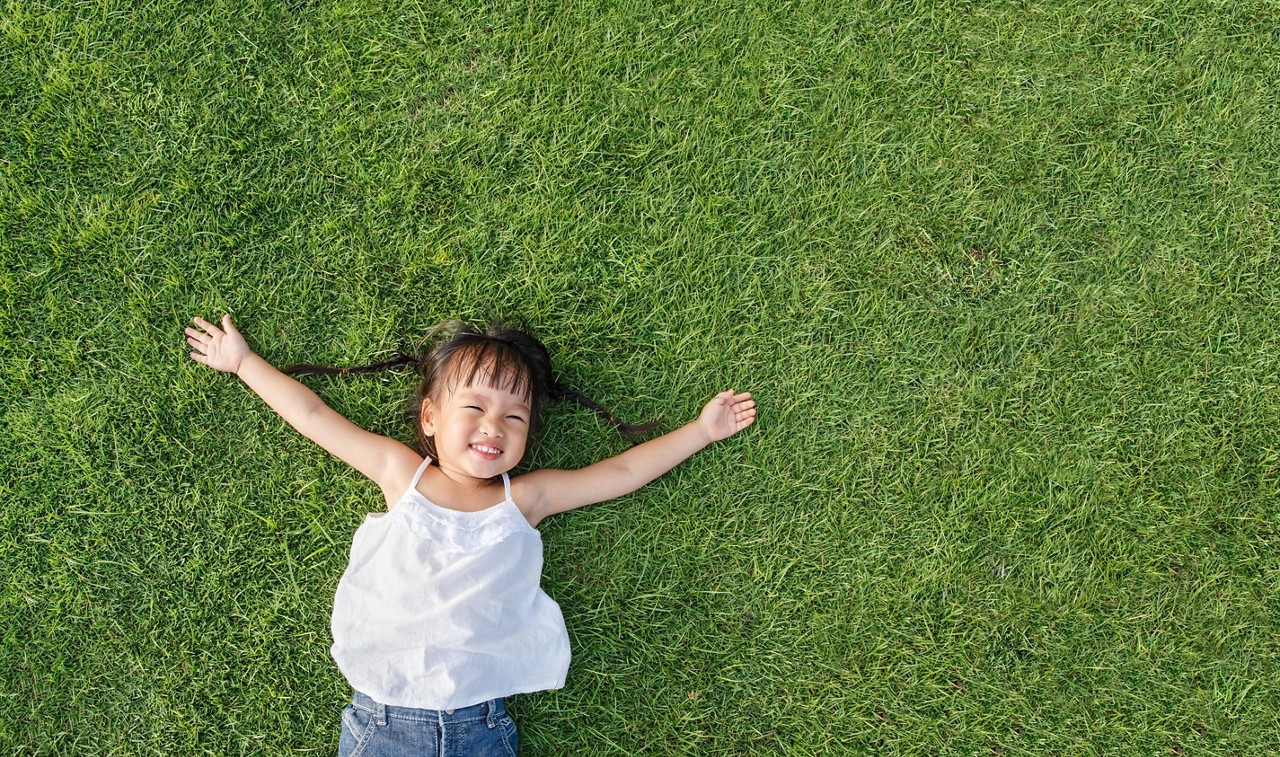 Asian little girl smile and lay on grass; Shutterstock ID 217743628; purchase_order: 4503446214; job: ; client: ; other: 