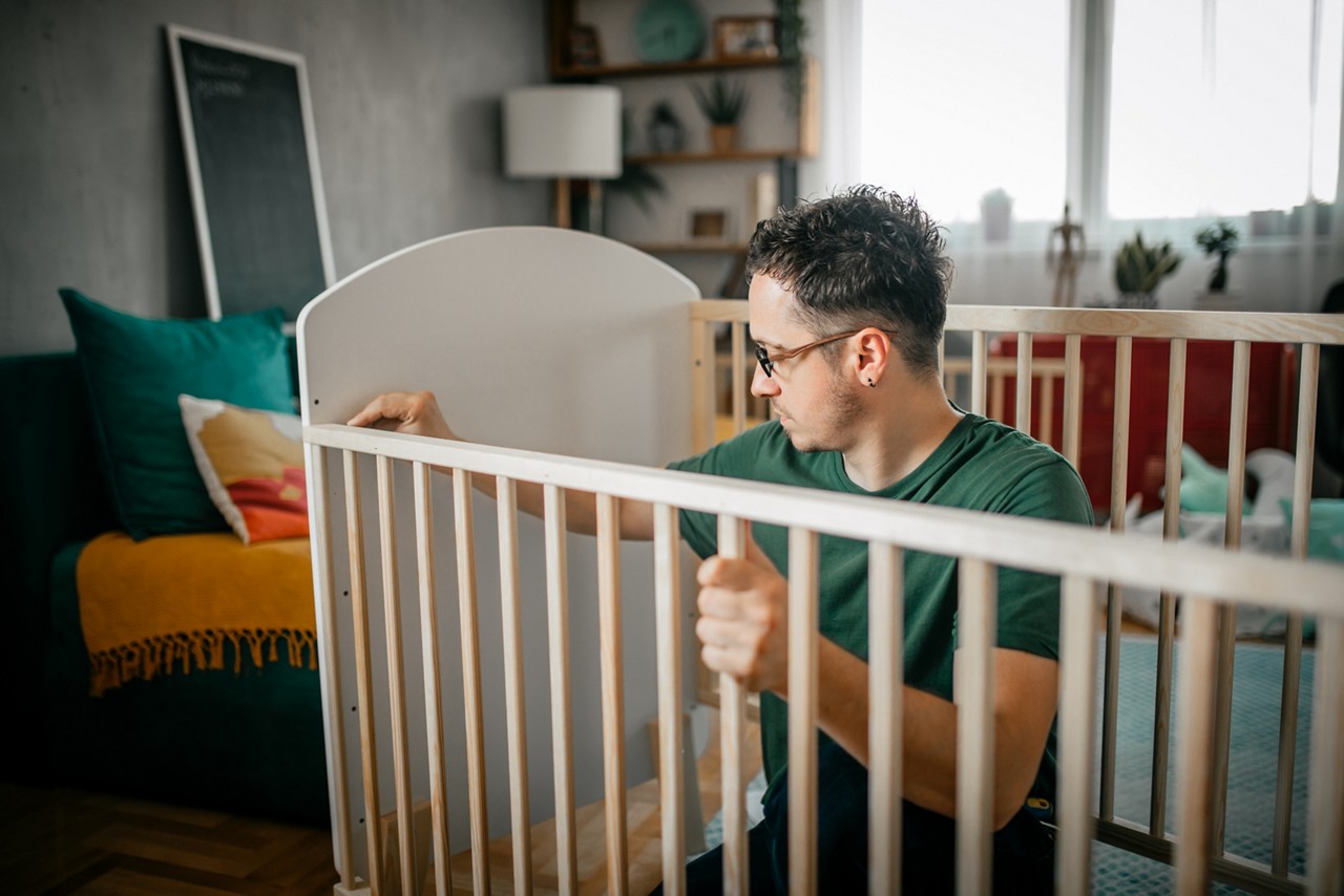 Papa qui monte le lit de bébé