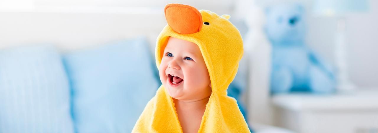 Bebê sorrindo vestindo um capuz de toalha