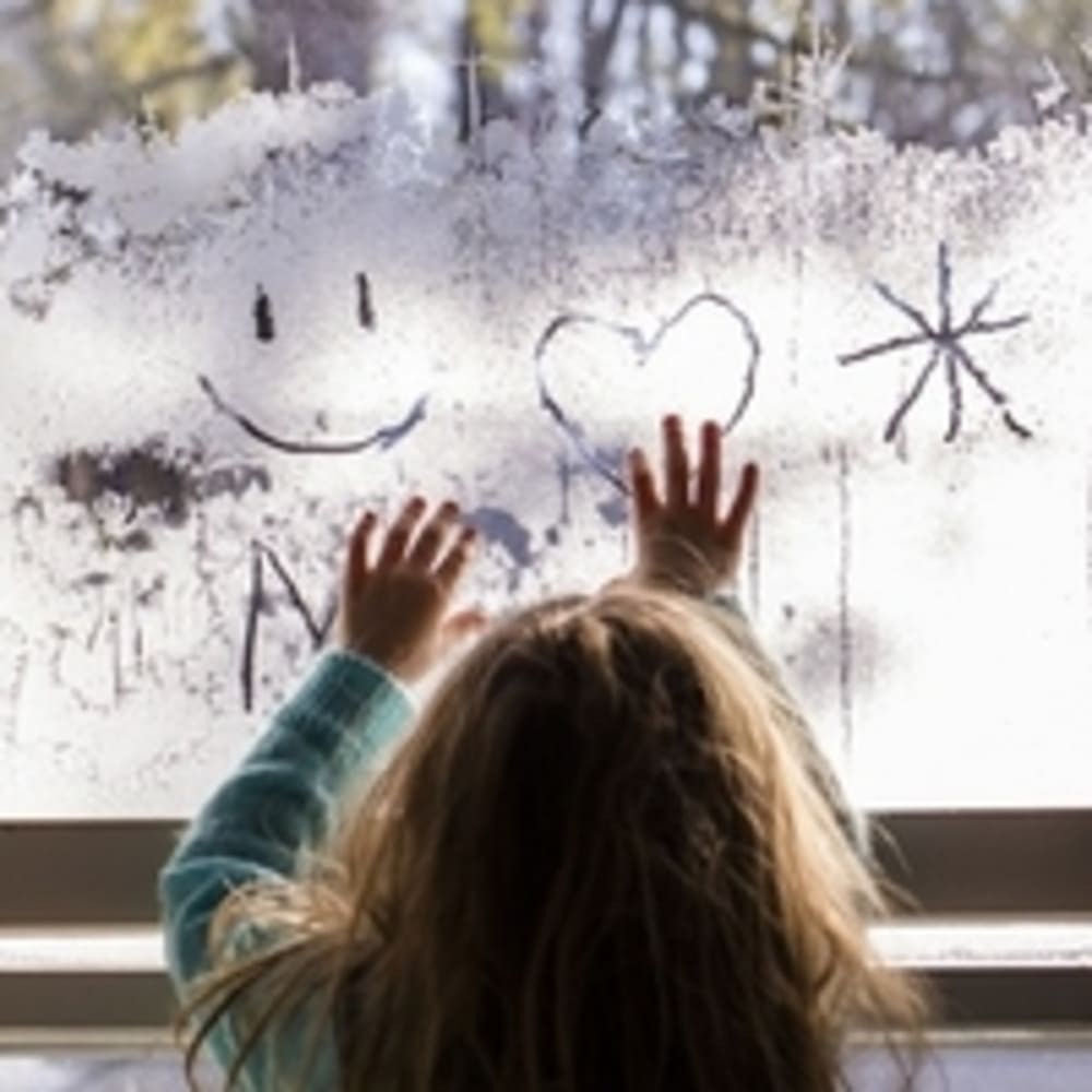 Enfant dessine vitre buee