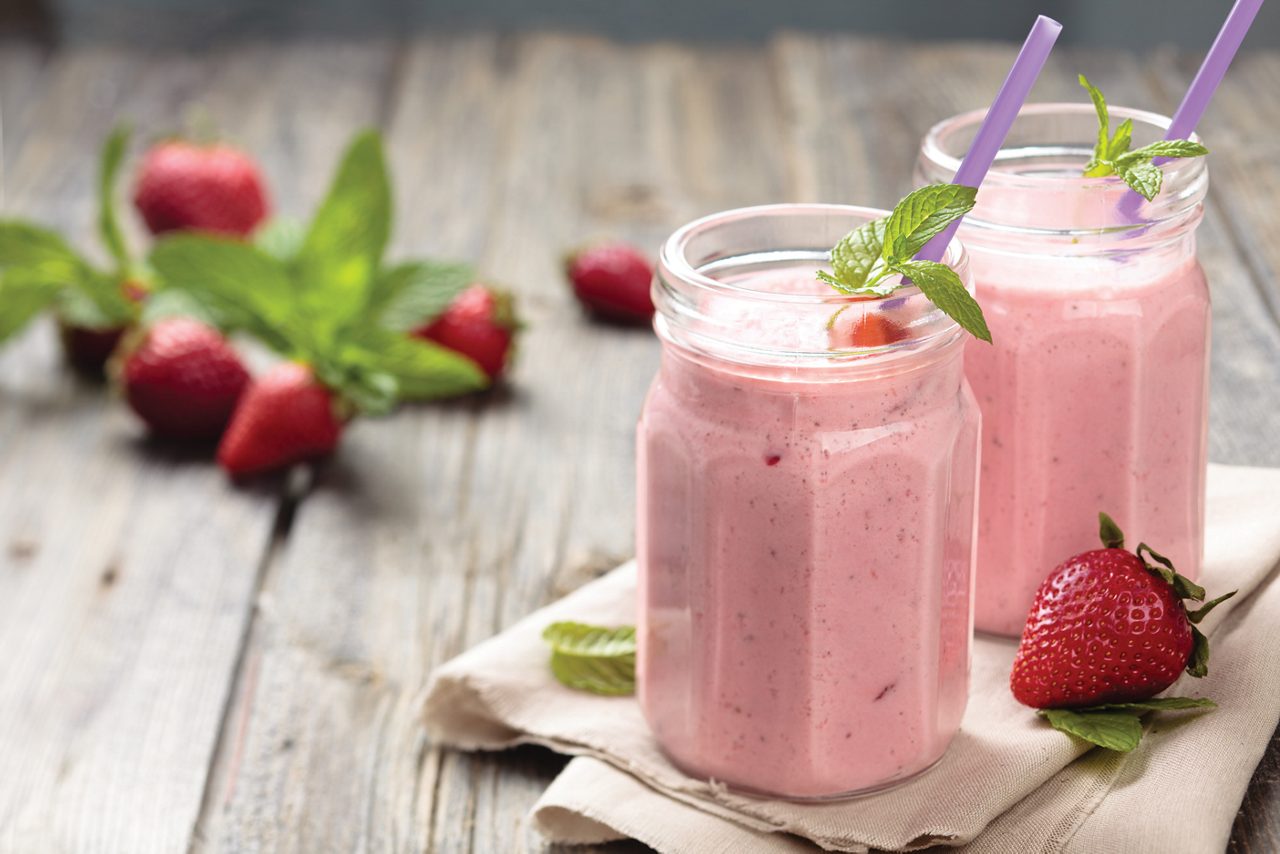 Strawberry milkshake in glass with straw