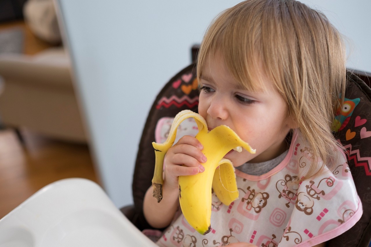 Toddler eating banana
