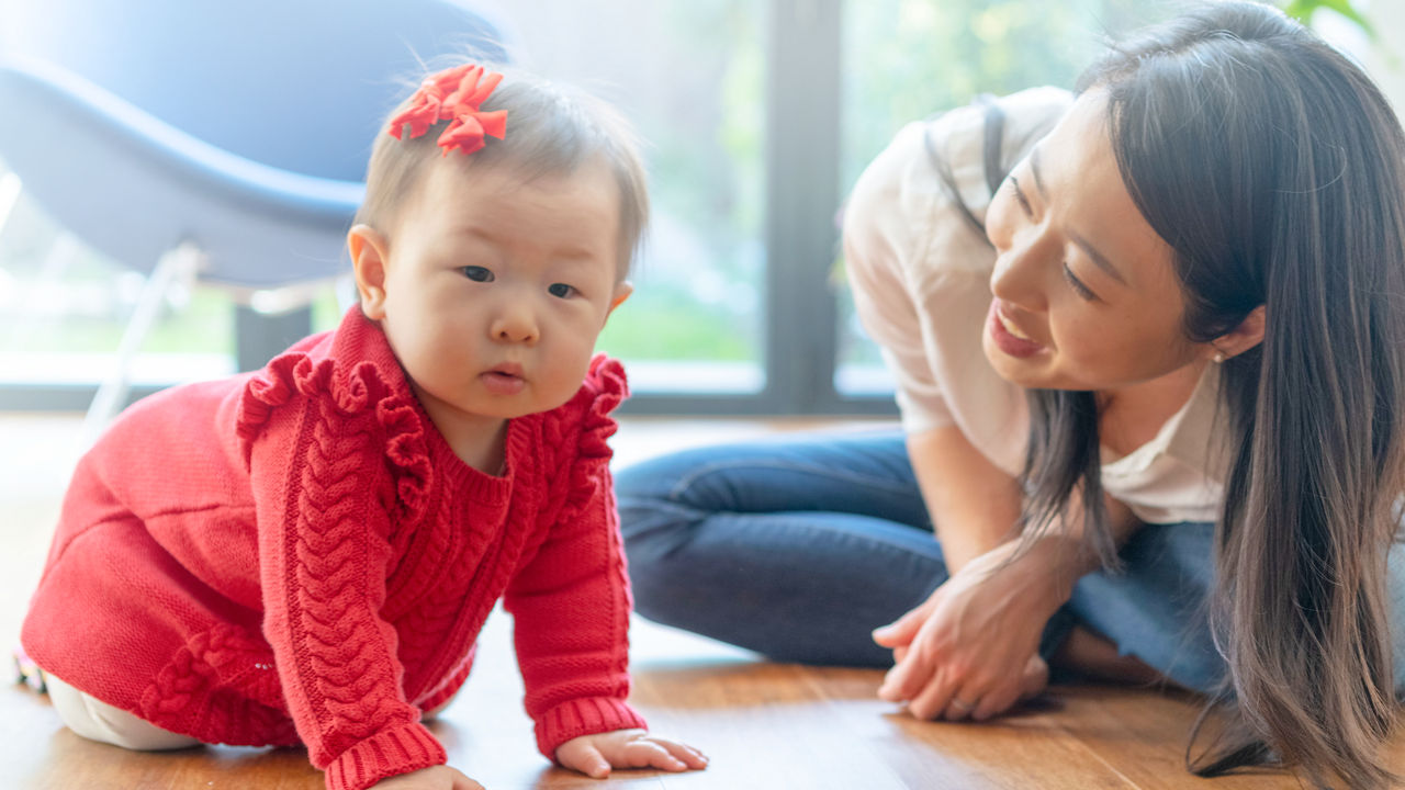 Mother playing with baby on the floor