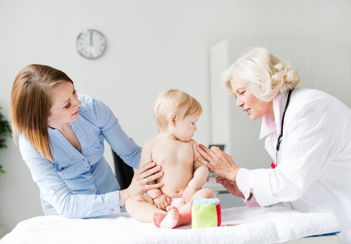 Cute baby girl receiving vaccine, mother next to her