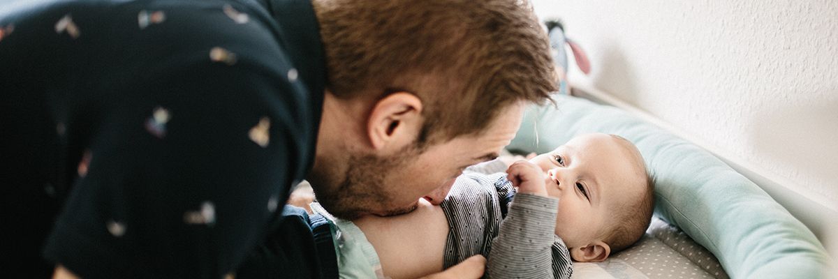 Vater küsst Baby auf den Bauch