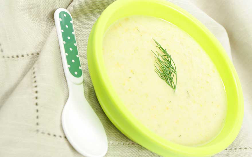 Soupe cremeuse dans un bol vert avec une cuillere