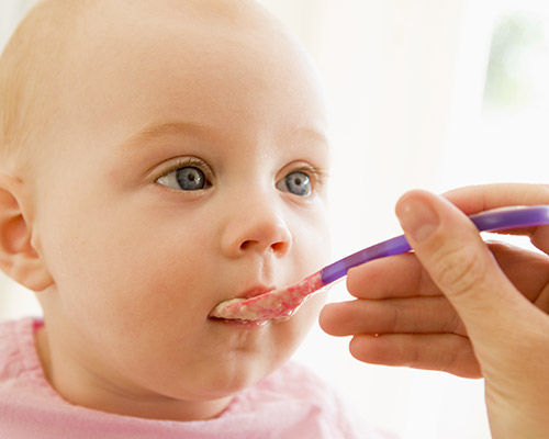 Baby being fed by spoon
