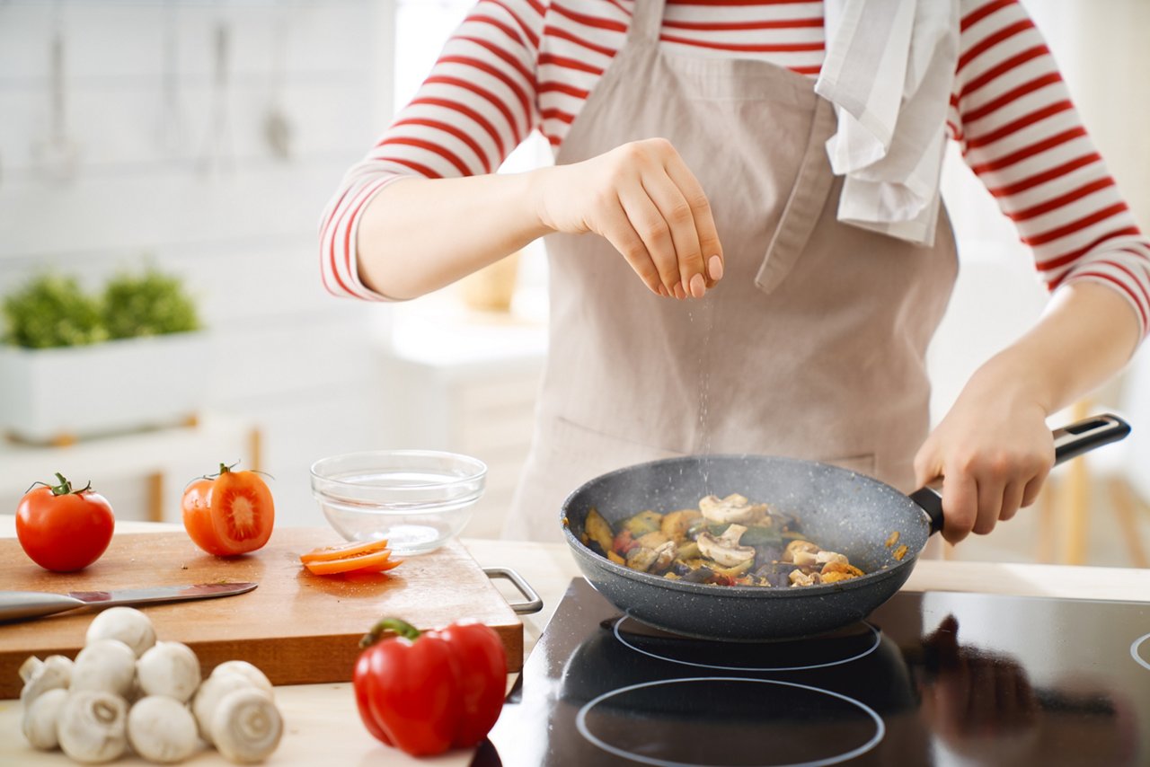 Woman is preparing a meal in the kitchen.