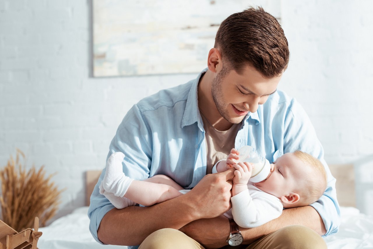 Father feeding baby with a baby bottle