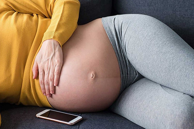 mujer embarazada de 27 semanas tocándose el abdomen