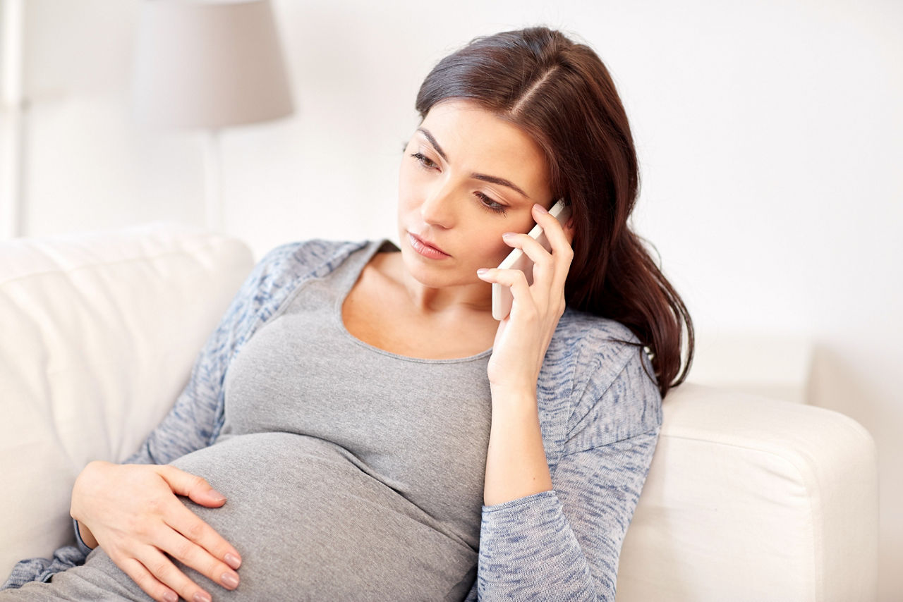 pregnancy, motherhood, technology, people and expectation concept - sad pregnant woman calling on smartphone at home