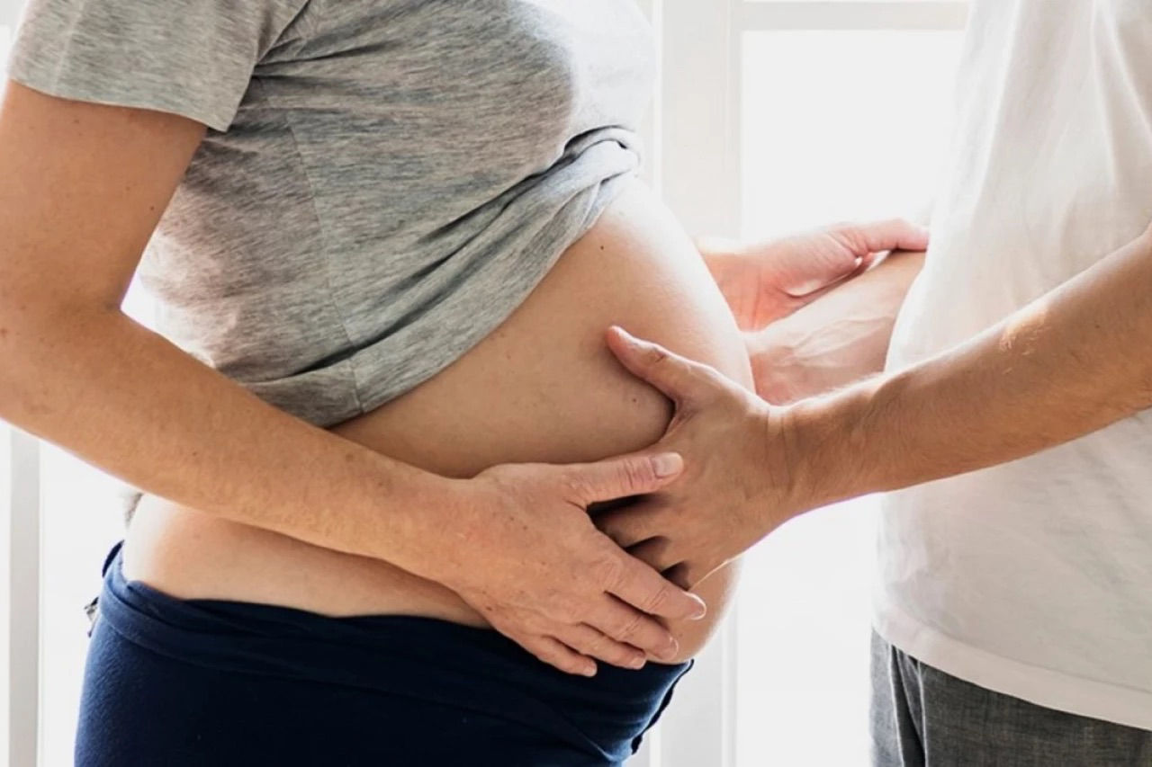Man feeling expectant mothers bump