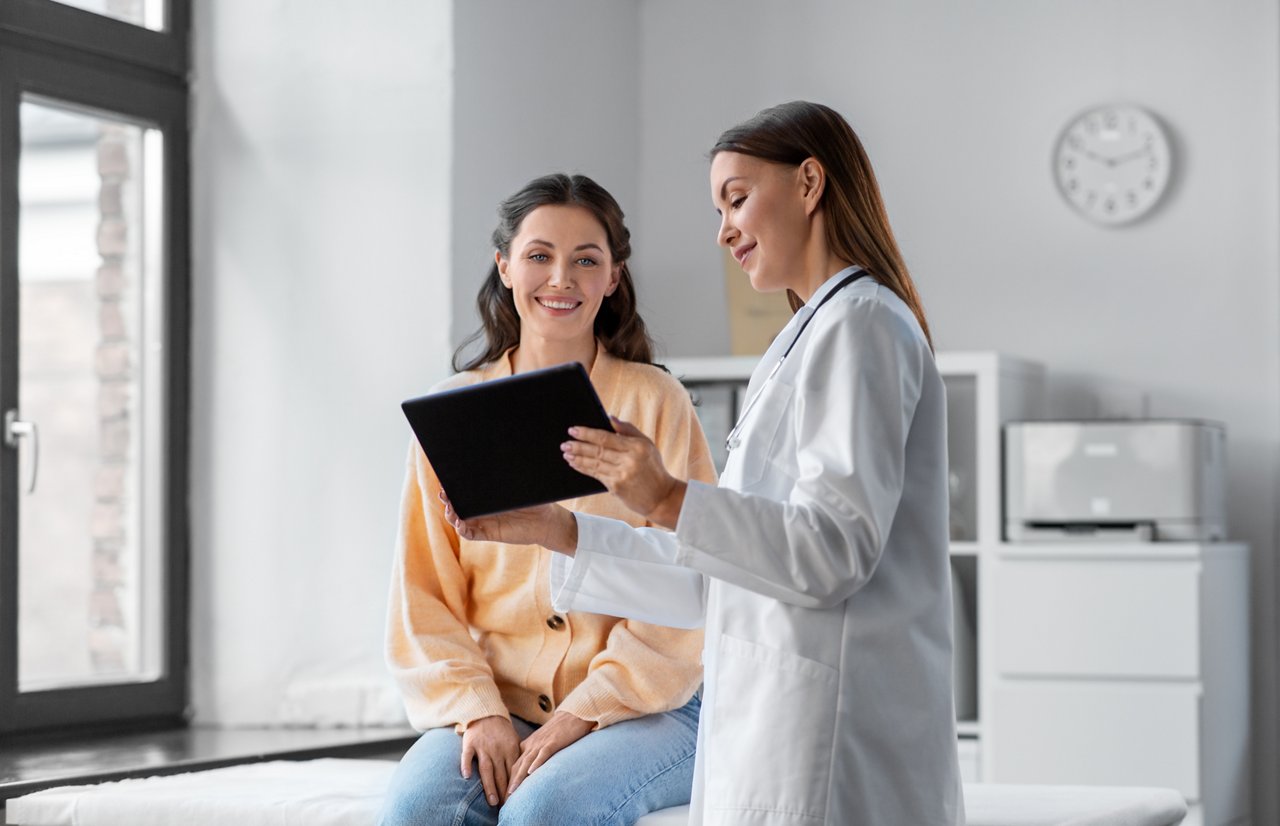 Doctor with tablet talking to patient at hospital