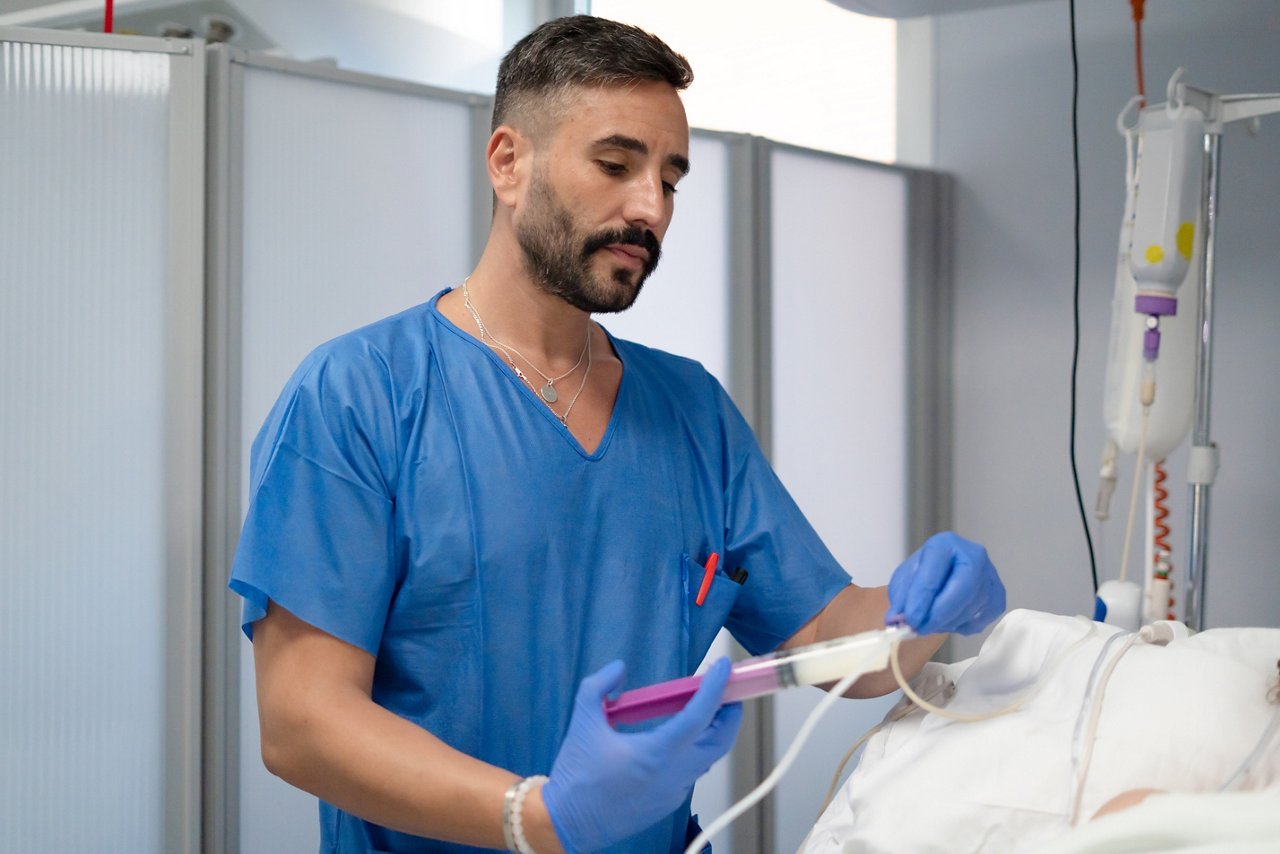 Nurse providing nutrition to a patient in a sterile hospital environment