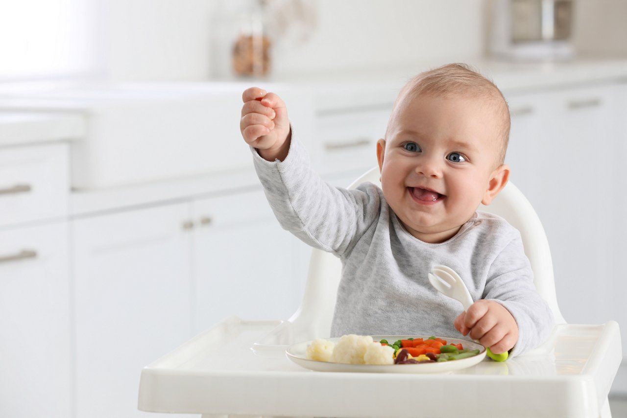 Baby eating vegetables at home