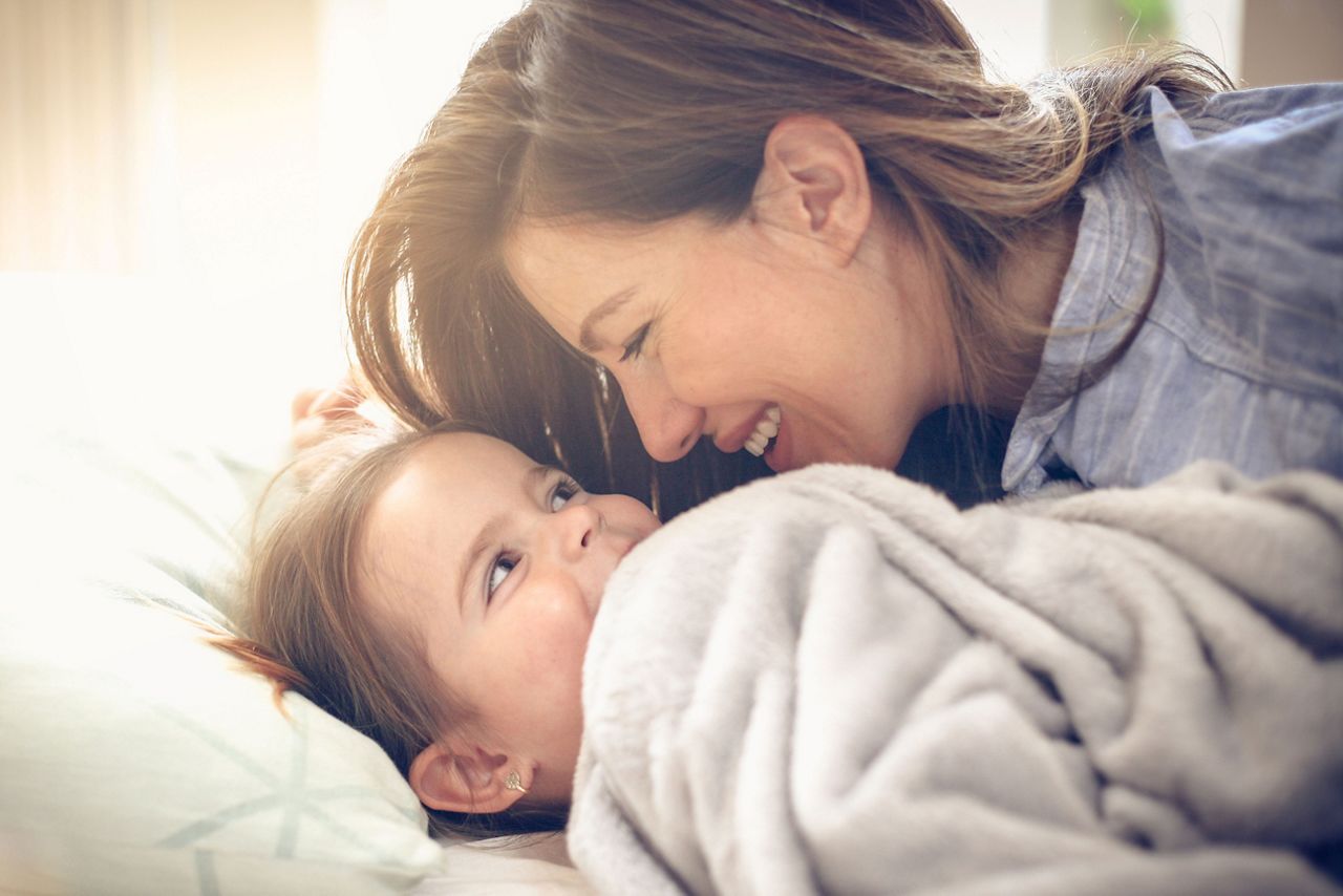 Kleinkind schläft auf der Schulter der Mutter