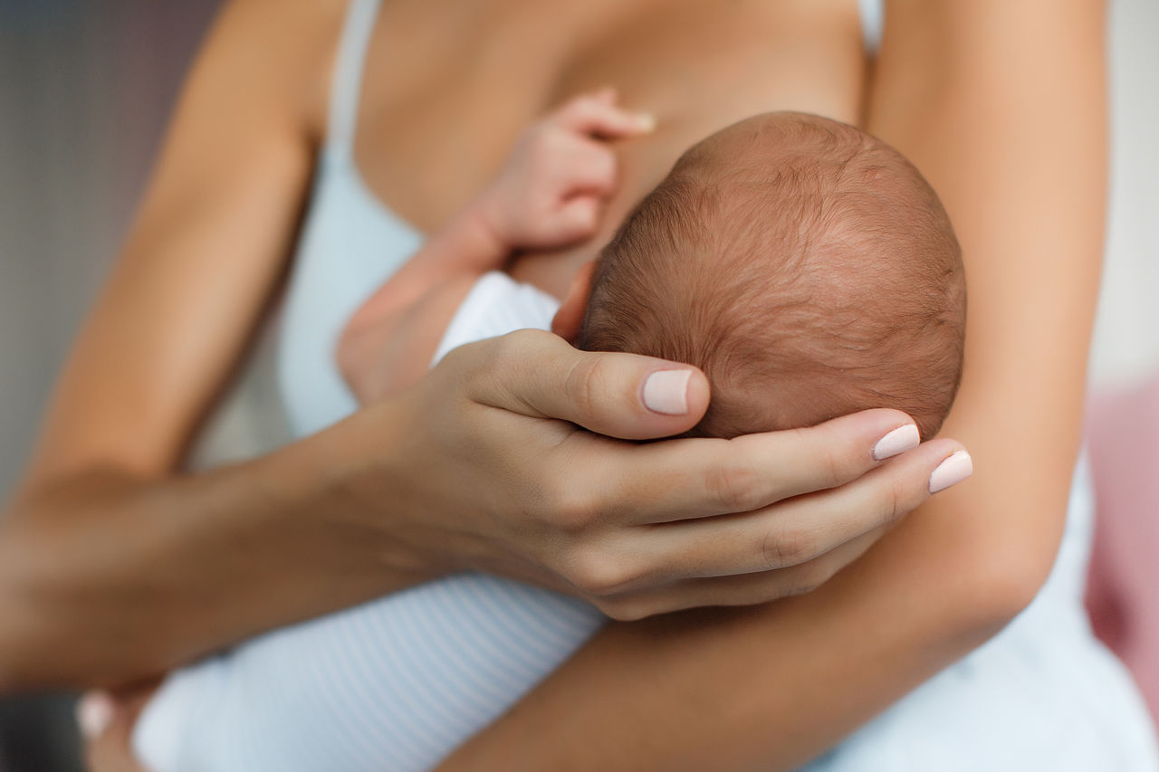 baby touching mother during breastfeeding 2