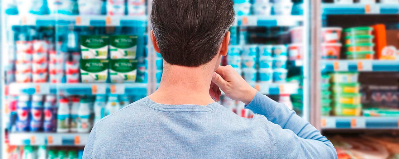 Mann wählt Activia-Joghurts im Supermarkt aus