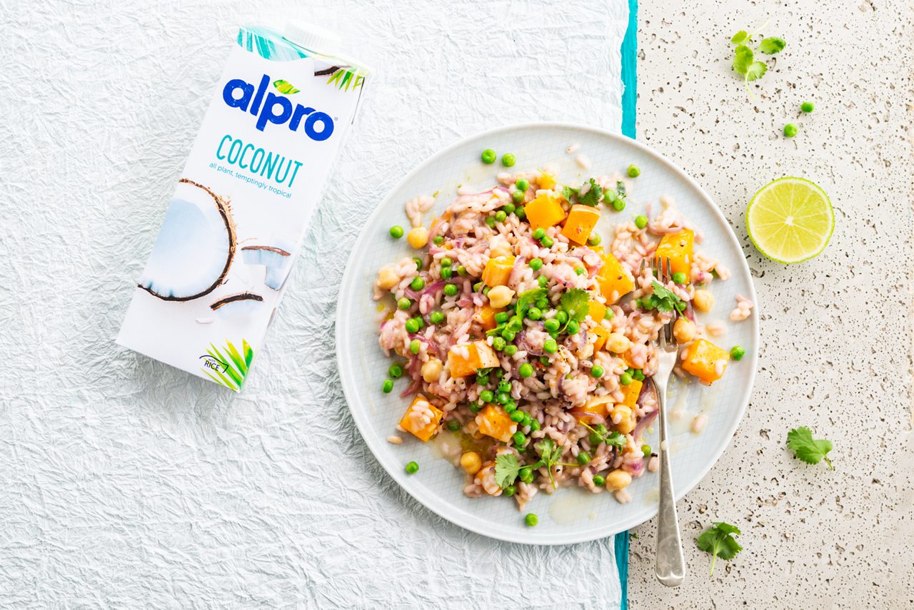 11640E1C-C7A1-4A2A-881FC6D66F87D1C4<br>A_GFY_NA_Master_Recipe_Image_SquashRisotto_3x4__Drinks_NS_coconut_NA_TetraUHT_1l_HR_horizontal-048.tif<br>Spiced Chickpea and Squash Risotto 
An aromatic one-pot wonder made with Alpro Coconut Drink Original 
"45ml (3 tbsp) vegetable or mild olive oil
2 large red onions, finely sliced
3 cloves garlic, peeled & finely chopped
1 medium-hot chilli, deseeded & finely chopped
20g fresh root ginger, peeled and finely chopped (optional)
275g Alborio or Carnaroli risotto rice
900g squash or pumpkin, peeled, deseeded & cut into 1 cm cubes
250g leeks, cabbage or peas (or a mixture of them all)
1 vegetable stock cube dissolved in 500ml boiling water, kept warm on the hob
550ml Alpro® Coconut drink
400g can or carton chickpeas, drained & rinsed
Zest & juice of 2 limes
Salt & pepper, to season
Chopped fresh coriander to garnish"
"1. In a large saucepan, heat 30ml/2 tbsp of the oil and cook the onions over a low heat for 10 minutes, giving them an occasional stir. Cooking them long and slow like this makes them deliciously sweet! Then turn up the heat, add the garlic and chilli and cook for a further minute.
2. Now add the rest of the oil to the pan and pour in the rice, stirring well to make sure all the rice grains have a nice coating of oil. Add the squash or pumpkin and your choice of veggies and mix in.
3. And now, the secret of a successful risotto. Patience! Add the hot stock bit by bit, and keep on stirring over a medium heat until the rice has soaked it all up before adding more. So, start with 200ml of stock, then add the Alpro Coconut drink in the same way. It should take about 20-25 minutes.
4. Now pour in the chickpeas, the zest & juice of the limes and season to taste. Serve straightaway with a scatter of the chopped fresh coriander. It’s all the colours of autumn on a plate."
lactose free, gluten free, veggie, vegan
/squash-risotto
(Recipe type: MAIN (Prep time: 35 min) (cooking time: 25 min) (baking time: x min) (cooling time: x min) (servings: +/- 6 persons) (season: autumn) (pool: 1) NOT TO BE TRANSLATED
/
/
/
/
Alpro Coconut Drink Original
Alpro, Alpro recipe, main, risotto, pumpkin, squash risotto, pumpkin risotto, veggie risotto, italian