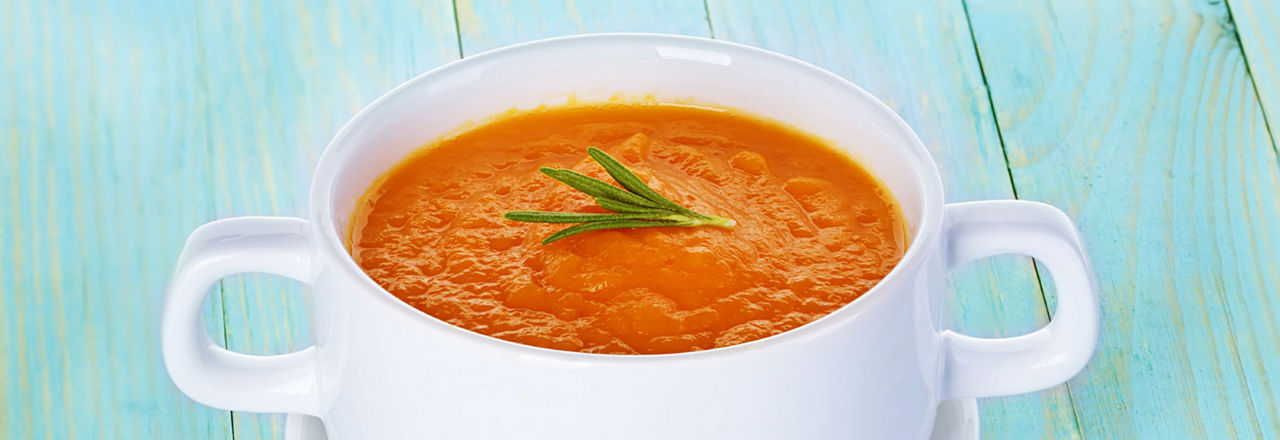 Pumpkin soup in a bowl on a wooden background