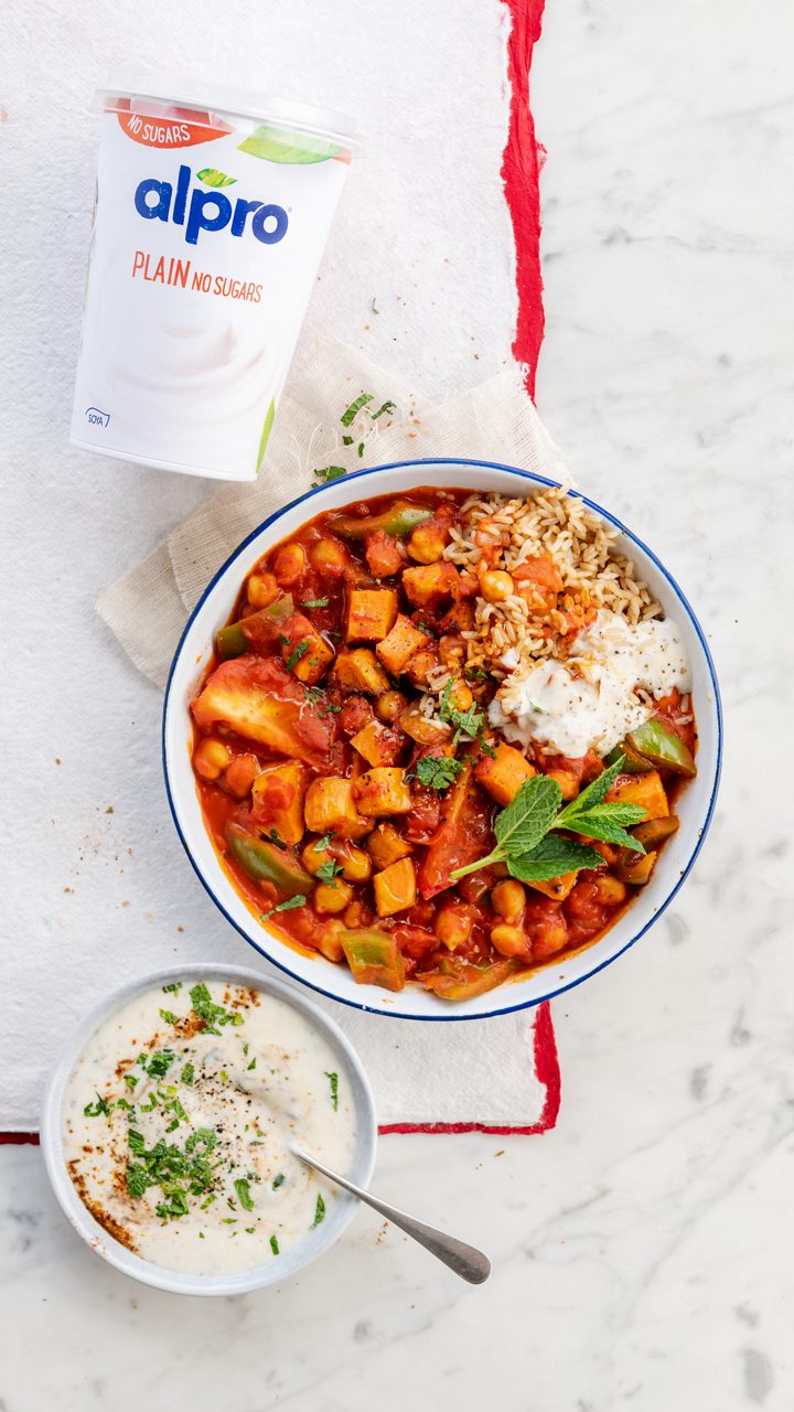 2697AE1A-E5EC-4A8C-96383F206CA897C9<br>A_GFY_NA_Master_Recipe_Image_SweetPotatoCurry_9x16__PBAY_NS_Soya_NA_POT_500g_HR-094.tif<br>Sweet Potato and Chickpea Curry
Quicker than a takeaway and made with Alpro Plain No Sugars plant-based alternative to yogurt
"For the curry:
1 medium size sweet potato, peeled and cut into 2cm chunks
2 tbsp rapeseed or sunflower oil, plus extra if needed
2 medium size onions, finely diced
3 garlic cloves, crushed
10g fresh root ginger, peeled and finely grated
1 tsp sweet paprika
2 tsps ground turmeric
1 tsp medium curry powder
¼ tsp hot chilli powder
1 tsp ground coriander
1 tsp garam masala
4 green cardamom pods, crushed
227g can chopped tomatoes
1 tbsp tomato purée
½ green pepper, deseeded and cut into 1cm pieces
1 green chilli, finely diced
250ml vegetable stock
2 fresh tomatoes, quartered
1 tsp salt,
400g can chick peas, drained and rinsed

For the garam masala raita:
150g Alpro Plain No Sugars plant-based alternative to yogurt
1 tsp garam masala
½ tbsp dried mint

Rice to serve"
"1. Start with a bit of roasting. Preheat the oven to 190C/170 fan/gas mark 5 and line a baking tray with baking parchment. Toss the sweet potato with 1 tbsp oil and spread out on the tray, then bake for 20-25 minutes until soft and slightly browned along the edges.
2. While that’s happening, add the rest of the oil to a medium saucepan and warm over a low-medium heat. Fry the onions, garlic and ginger for 8-10 minutes, or until very soft. Stir in the paprika, turmeric, curry powder, chilli powder, coriander, garam masala and crushed cardamom pods to make a nice thick curry paste. Cook for 1-2 minutes, adding a little extra oil if it gets dry.
3. Pour in the canned tomatoes, stir in the tomato purée and cook for 2-3 minutes to thicken up again. Mix in the vegetable stock, green pepper, green chilli, fresh tomatoes and salt, then siimmer gently on a low heat for 35-45 minutes. Finally add the chickpeas and roast sweet potato and heat until they’re warmed through.
4. To make the garam masala raita, just mix all the ingredients together and season to taste. Serve on the side with the curry and rice for a touch of tangy contrast."
lactose free, gluten free, veggie, vegan
/sweet-potato-curry
(Recipe type: MAINS (Prep time: 15 min) (cooking time: 50 min) (baking time: x min) (cooling time: x min) (servings: +/- 2 persons) (season: all year) (pool: 1) NOT TO BE TRANSLATED
/
/
/
/
Alpro Plain No Sugars plant-based alternative to yogurt
Alpro, Alpro recipe, curry, sweet potato curry, Indian, main, rice