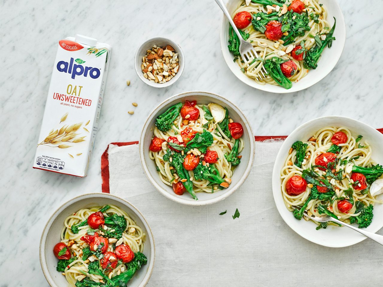 2BFE287D-5277-4897-A4E8994A61BF5FD4<br>R+T-Alpro_UnsweetenedRecipes-ManlyPasta_02610.jpg<br>Serves: 4
Total time: 50 minutes

Ingredients: 
4 garlic cloves
400g cherry tomatoes
Few sprigs thyme 
Olive oil
400g spaghetti
400g tenderstem broccoli
1 onion, finely chopped
1/2 tsp chill flakes
5 tbsp plain flour
1L Alpro Oat Unsweetened drink
½-1 lemon, juice
50g pine nuts
40g cashew nuts roughly chopped
40g almonds, roughly chopped

To serve:
Large bunch of fresh basil leaves
Drizzle of Extra Virgin Olive Oil

Method:
1.	Preheat the oven to 200C/180Cfan/gas mark 6. Put the garlic cloves and whole cherry tomatoes on a baking tray. Season with salt and pepper, thyme and toss through olive oil. Roast for 25-30 minutes until blistered and a little coloured, remove from the oven and set aside. 
2.	Meanwhile, bring a large pan of water to the boil and cook the pasta to pack instructions. Add the broccoli florets for the last 3 minutes of cooking time, then drain and set aside. 
3.	In a large deep saucepan, heat 2 tbsp of oil over a medium heat and add the onion. Gently fry for 5-8 minutes until softened and a little coloured. Add the chilli flakes and flour and fry for a few minutes until bubbling. 
4.	Remove from the heat and gradually add the Alpro Oat Unsweetened drink. Stirring all the time, then put over a medium heat and stir regularly until the sauce thickens and bubbles. Season with salt and pepper and a squeeze of lemon. Toast the pine nuts, cashews and almonds together until golden in a small non-stick frying pan.
5.	Toss the spaghetti and broccoli through the sauce. Top with the roasted tomatoes, toasted nuts, a handful of fresh basil and drizzle of olive oil.