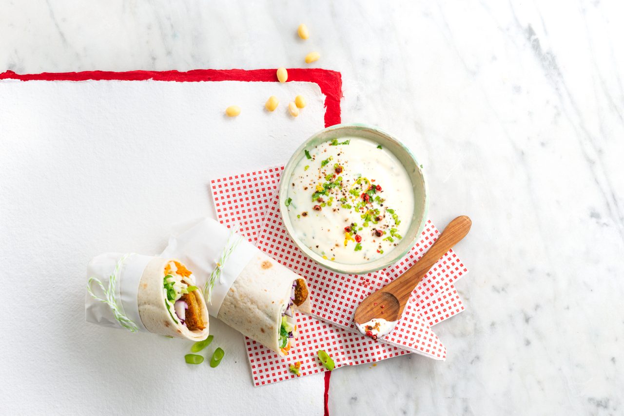 8F26BD4F-DB38-449C-A81927D8E4750DC1<br>A_GFY_NA_MASTER_Recipe_Image_FalafelWrap___PBAY_NS_Soy_NA_Pot_500g_HR_horizontal-067.tif<br>Fabulous falafel wrap with a tangy dip
A summery salad and falafel wrap and delicious dip with Alpro no sugars plain 
"For the dip:

100ml No sugars plant based alternative to yogurt
1/2 lemon, juice and zest
1/2 garlic clove
4 fresh coriander stalks
1/2 Red chili pepper

Wrap:

3-4 falafel
1 spring onion
1 carrot
100gr white cabbage, finely sliced
100gr red cabbage, finely sliced 
1/2 avocado
2-4 wraps"
"1. If you want to bake your falafels, preheat your oven to 180º now, then do the dip. Chop the coriander, and crush or finely dice the garlic. Mix into the No sugar plant based alternative to yogurt along with the red pepper and a squeeze of lemon juice. Pop into a bowl and finish with a topping of extra pepper, chopped coriander and a little grated lemon zest.

2. Now for the falafels. Either bake them with a drizzle of olive oil in your pre-heated oven, or heat the olive oil in a pan and cook them over a medium heat, turning until thy’re crusty and golden all over. Then season with a twist of sea salt and black pepper. Put to one side until you’re ready.

3. Make your salad. Finely slice the red and white cabbage into thin strips, grate the carrot, slice the avocado and chop the spring onion.

4. Now the exciting bit, putting it all together. Warm the wrap for 30 seconds in an oil free pan over a medium heat. Start the filling with a dollop of dip in the middle of the wrap, then add the falafels, cabbage, carrots, avocado slices and spring onion. Season to taste and add more dip if you like. Then fold it all up, serve with the dip and enjoy!
(Recipe type: Dinner LUNCH / DINNER (Prep time: 15 min) (baking time: 10 min) (cooling time: 5 min) (servings: +/- 2 persons) (season: all year) (pool: 1)