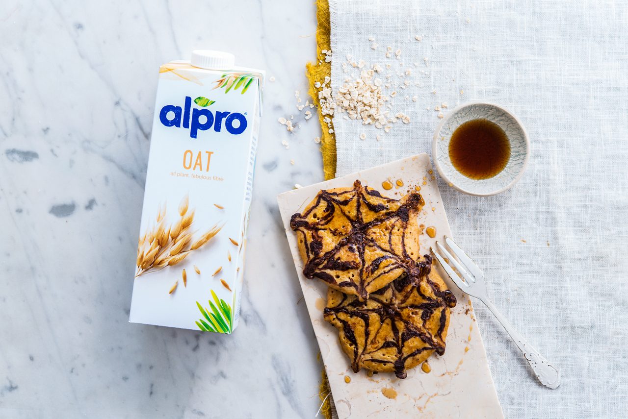 67DF1772-E655-4EE2-A9CDA84100150177<br>A_NA_NA_Master_Recipe_Image_halloweenpumpkinpancakespackshot___Drinks_NA_Oat_NA_TetraUHT_1l_HR_horizontal<br>Halloween pumpkin pancakes
with Alpro Oat drink

"The pancakes:
400g pumpkin, cubed 
1 egg 
200ml Alpro Oat Drink 
2 tbsp Maple or Agave syrup 
200g spelt flour 
2 tsp baking powder 
1 tbsp gingerbread spices 
Butter, margarine or vegetable oil
Salt 

Chocolate spider webs:
100g pure chocolate (70%)
60ml Alpro Oat Drink 
4 tbsp spelt flour
Salt
Extra maple syrup for serving"

"1.	Steam the pumpkin cubes until soft, then drain and purée with a hand blender (or potato masher if you don’t have one).
2.	Make the pancake batter. Mix the pumpkin purée with the egg, Alpro Oat Drink and maple or agave syrup. Add the flour, baking powder, gingerbread spices and a pinch of salt and whisk together until you have a smooth batter. Put to one side.
3.	For the chocolate webs. Gently melt the chocolate in a bowl over hot water, stirring well, let it cool a little then whisk together with the Alpro Oat Drink, flour and water so it makes a smooth batter. Pour it into a fine-pointed piping cone (or a squeezy bottle will do the job, too).
4.	Cook the pancakes. Heat a little butter or oil in a frying pan and spoon in the batter to make four little pancakes each about 8cm across. Cook for a few minutes until the underside is golden brown. 
5.	Now the fun begins! Using the piping cone, carefully draw chocolate webs onto the uncooked top side, flip over and complete the cooking. Carry on until all the batter is used up – you should get 20-25 pancakes altogether. Serve drizzled with extra maple syrup. Spookily delicious!"