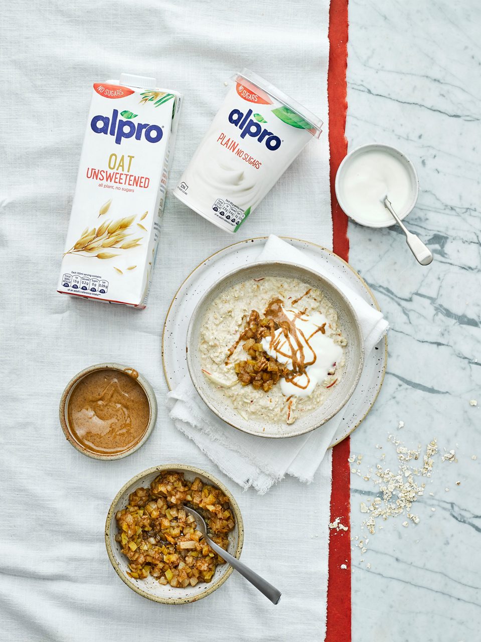 E1A8545B-C09C-4F41-ADE797C5924D6D09<br>R+T-Alpro_UnsweetenedRecipes-OvernightOats_02211.jpg<br>Serves: 2 (or 3-4 small portions) 
Total time: 30 minutes + overnight chilling in fridge

For the oats:
1 apple, cored and finely grated
1 pear, cored and finely grated
150g oats
350ml Alpro Oat Unsweetened drink 
1/2 tbsp maple syrup
4 tsp almond butter 
Pinch sea salt

For the compote:
1 apple, finely chopped
1 pear, finely chopped
½ tsp cinnamon
Large pinch ground ginger

To serve: 
Alpro Plain No Sugars Big Pot

Method:
1. Mix the apple, pears, oats and Alpro Oat Unsweetened drink together in a medium mixing bowl, then stir in the maple and half of the almond butter. Add the pinch of salt, cover with cling film and store in the fridge overnight (about 12 hours).

2. For the compote, put the apple and pear into a sauce pan with 2 tbsp of water, maple syrup and spices. Put a lid on the pan and gently simmer on a low-medium heat for 10-15 minutes until the fruit has softened and broken down a little, stir occasionally. Set aside, cool and cover until morning. 

3. To serve spoon the oats into bowls and top with a spoonful of Alpro Plain No Sugars Big Pot, the remaining almond butter and the compote.