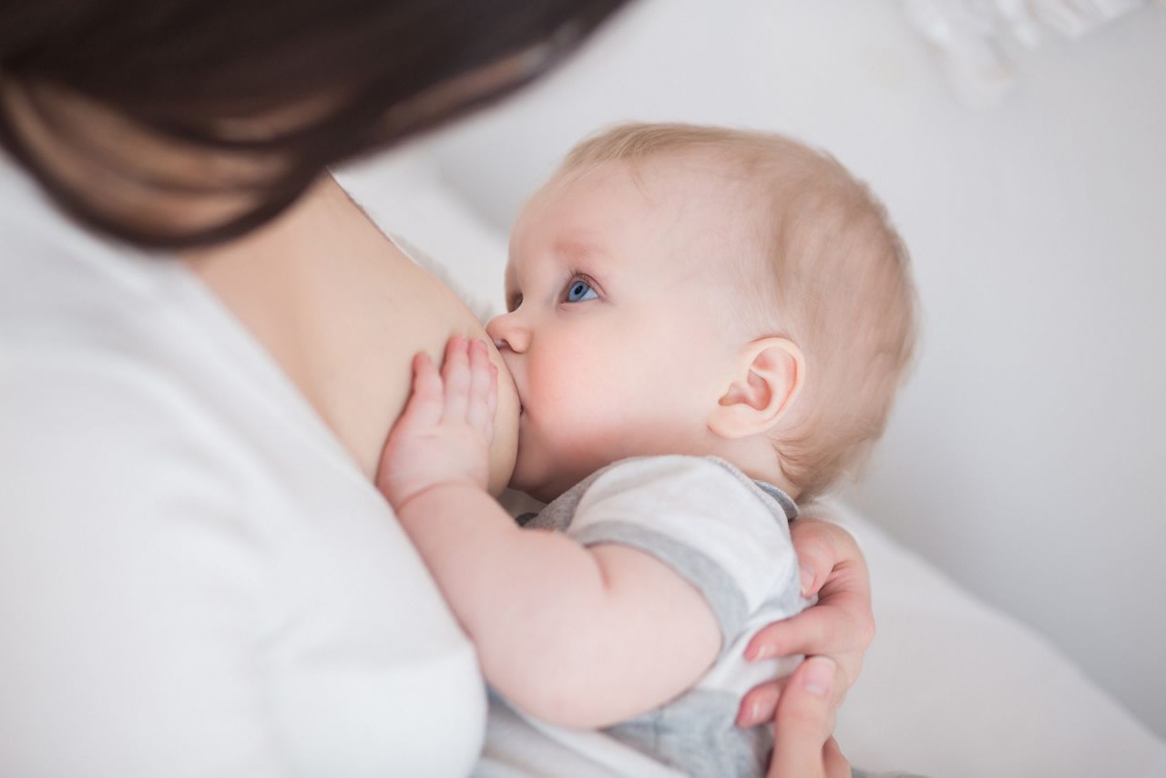 mother breast feeding and hugging her baby