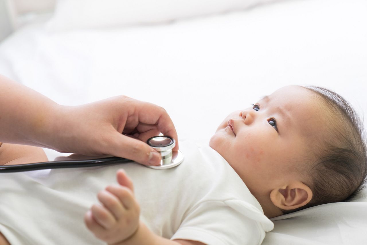 Doctor exams Asian newborn baby with stethoscope in the hospital