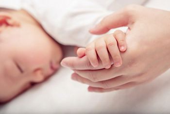 Hand the sleeping baby in the hand of mother close-up (Soft focus and blurry)