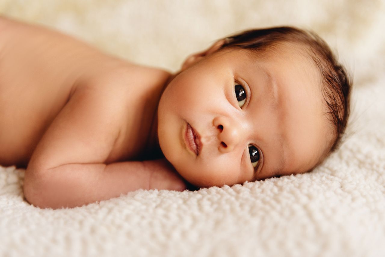 Newborn baby boy lying in a crib. Child preparing to sleep