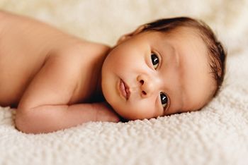 Newborn baby boy lying in a crib. Child preparing to sleep