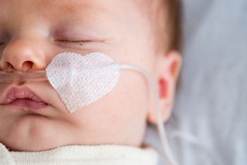 Newborn baby in hospital weakened with bronchitis is getting oxygen via nasal prongs to assure oxygen saturation, Newborn baby in hospital weakened with bronchitis is getting oxy