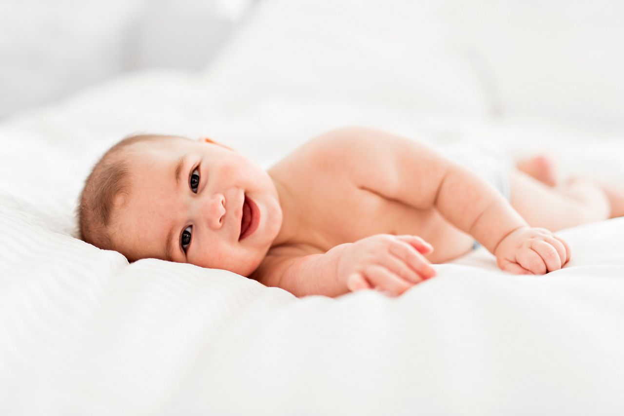 A Portrait of a baby boy on the bed in bedroom