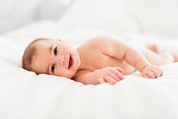 A Portrait of a baby boy on the bed in bedroom