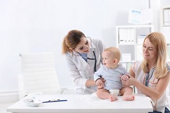 Woman with her baby visiting children's doctor in hospital